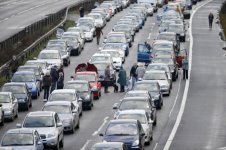 drivers-and-passengers-stand-next-to-their-cars-in-a-long-traffic-jam-after-a-fatal-crash-caused.jpg